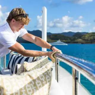 Deckhand cleaning the rails