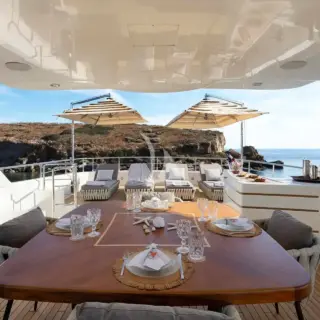 The spacious unobstructed sundeck has a jacuzzi pool with a large sunbathing area all around it, a bar, a dining table and sunbeds