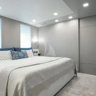Guest Stateroom Jan. 2023: white bedding with deep charcoal accent pillows
